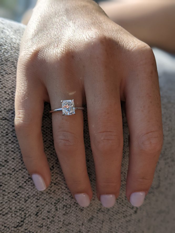 Bella ring - 1.14 carat cushion cut diamond ring on a finger
