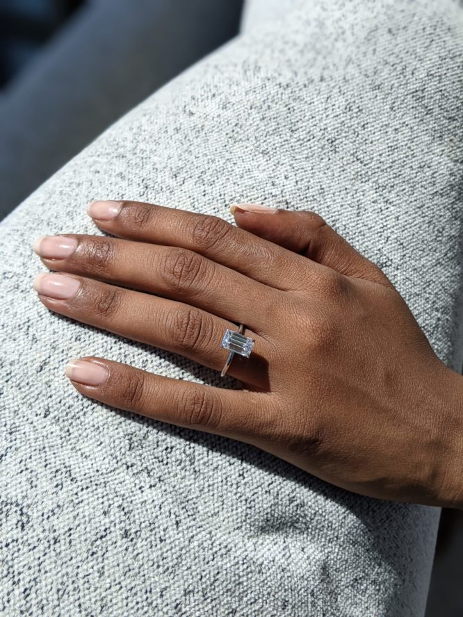 Charlotte emerald cut diamond ring worn on a finger
